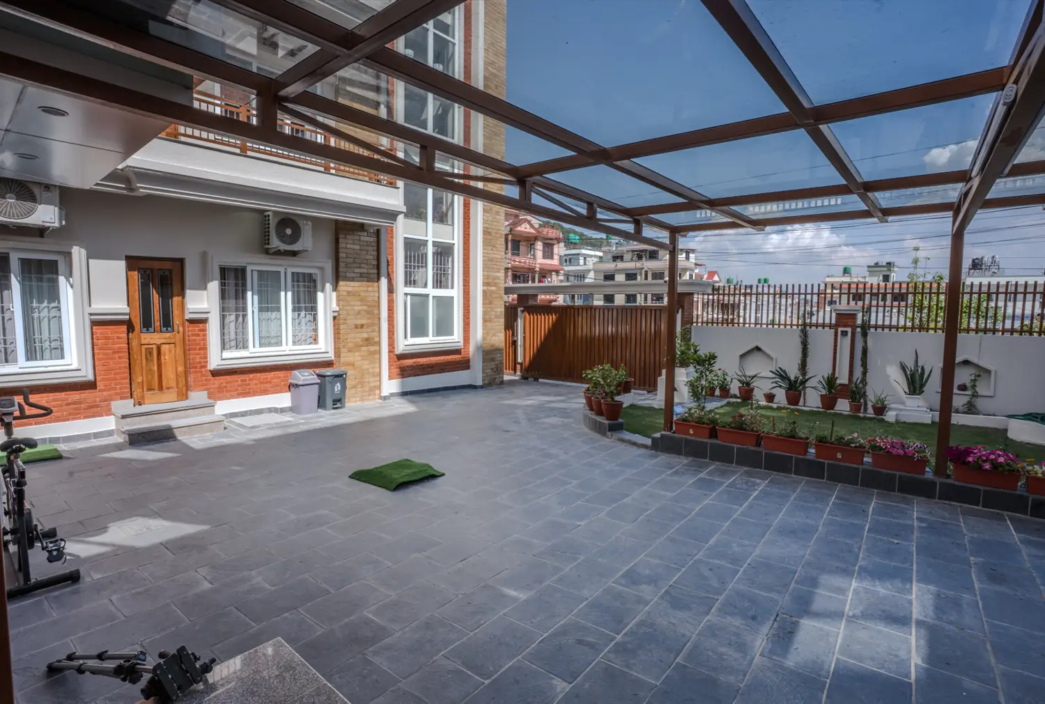 Stone-paved courtyard under a glass pergola